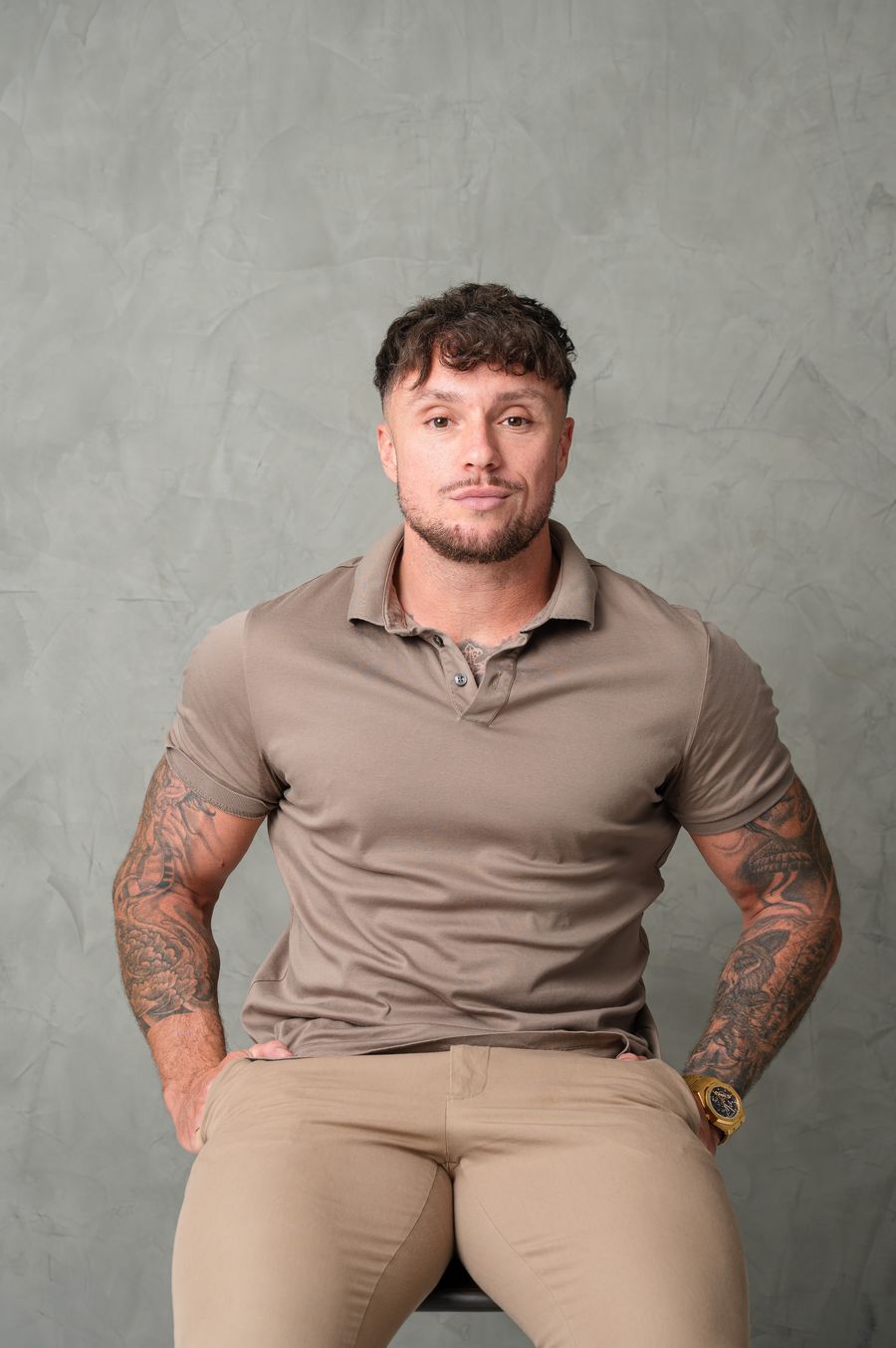 Portrait of Mitchell Galvin, Director of MGO Software Ltd, seated in a taupe polo shirt against a grey textured wall